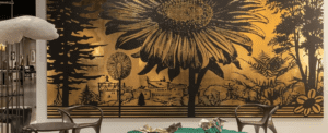 A black and gold sunflower painting on a wall.